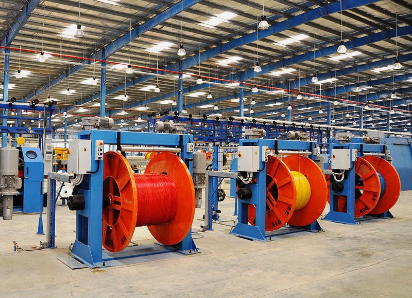 Cable reels and manufacturing machinery inside a workshop